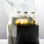 A six pack of beer in a translucent plastic bag lit to make the scene seem ghostly